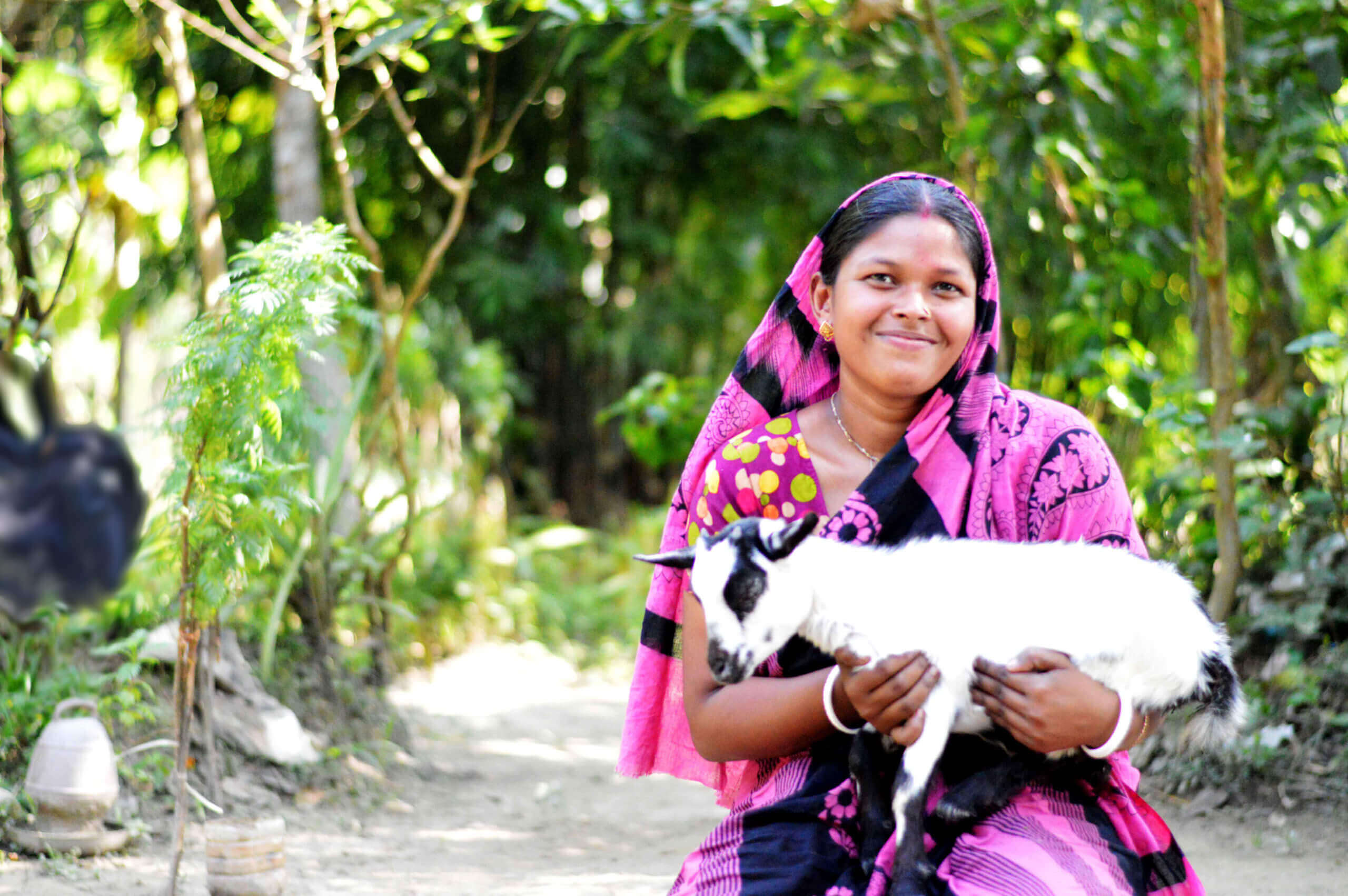 A woman entrepreneur poses with the newest member of her farm